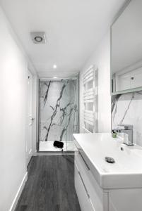 a white bathroom with a sink and a shower at Castle Street Apartments - Luxury Kilchattan Apartment in Rothesay +19 photos