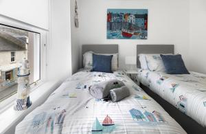 a bedroom with two beds with a stuffed animal on it at Castle Street Apartments - Luxury Kilchattan Apartment in Rothesay