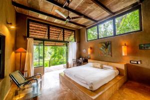 a bedroom with a large bed and a large window at Mahua Vann Pench in Khawāsa +70 photos