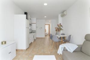 kuchnia i salon z kanapą i stołem w obiekcie Apartamento Perez Zara 7 w mieście Conil de la Frontera