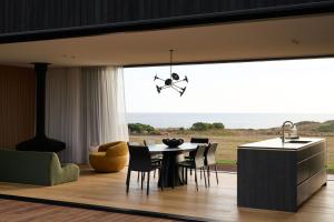a kitchen and dining room with a table and chairs at Zoarii Luxury Beach Front Wellness Stay in Ventnor