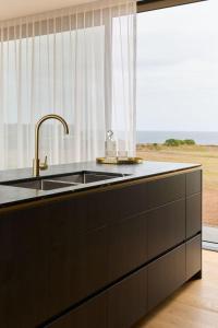 a kitchen with a sink and a window at Zoarii Luxury Beach Front Wellness Stay in Ventnor +42 photos