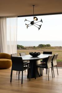 a dining room with a table and chairs at Zoarii Luxury Beach Front Wellness Stay in Ventnor