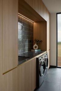 a kitchen with a washer and dryer in a cabinet at Zoarii Luxury Beach Front Wellness Stay in Ventnor