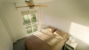 a bedroom with a bed and a ceiling fan at Apartamento en Playa Honda - La Manga in Cartagena
