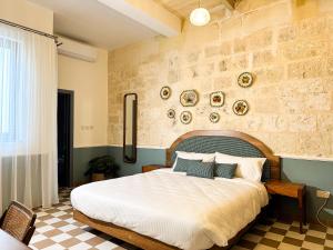 una camera da letto con un letto grande e un muro di mattoni di Il Bekka Suites a Rabat