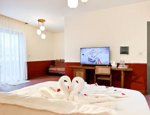 due cigni bianchi seduti su un letto in una stanza di Il Bekka Suites a Rabat