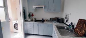 a white kitchen with a sink and a microwave at Apartamento en Playa Honda - La Manga in Cartagena +8 photos
