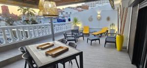 a patio with tables and chairs on a balcony at El Bungalow in Playa Fañabe