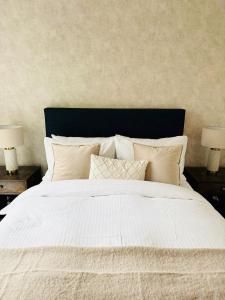 a large white bed with pillows and two lamps at Maidstone Apartment - Perfect For Contractors, Business Trips - Long Stays in Maidstone
