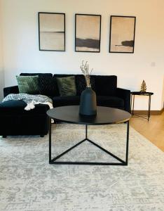 a living room with a black couch and a table at Maidstone Apartment - Perfect For Contractors, Business Trips - Long Stays in Maidstone +15 photos