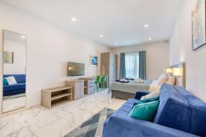 a living room with a blue couch and a tv at Stylish Apartment in Bay Square 2 in St Paul's Bay