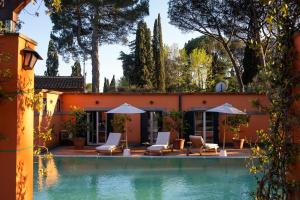 a house with a swimming pool with chairs and umbrellas at Hero's Garden Relais in Rome