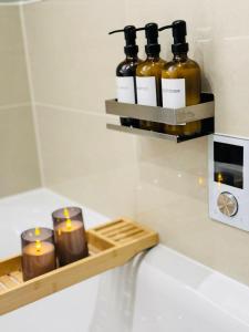 a shelf with candles on a counter in a bathroom at Maidstone Apartment - Perfect For Contractors, Business Trips - Long Stays in Maidstone