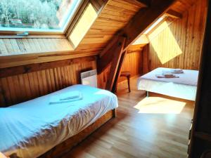 a bedroom with two beds in a wooden cabin at Les oulles 13 in La Chapelle-en-Valgodemard