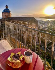 a table with a plate of food and a cup of coffee at Casa Al Plumbago in Termini Imerese