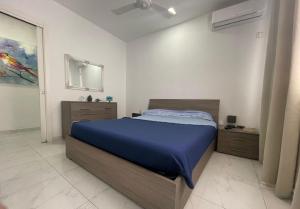 a bedroom with a bed with a blue blanket at Sapore di Mare apartment in St. Paul's Bay