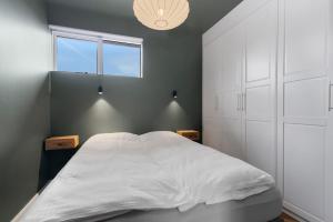 a bedroom with a large white bed and a window at New Charming Apartment in Reykjavík