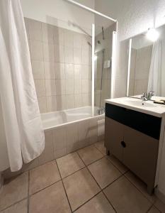 Un baño con bañera, lavabo y ducha. en SAINT FLORENT - Studio 2 pers résidence piscine FLO 18, en Saint-Florent