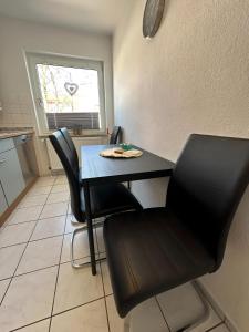 a dining table and chairs in a kitchen with a table at FeWo Lindenallee III Modernes Apartment in Nordhorn