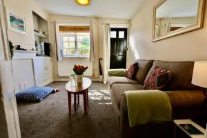 ein Wohnzimmer mit Sofa und Tisch in der Unterkunft Deben Cottage, Central Woodbridge in Woodbridge