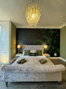 a large bedroom with a large bed with a chandelier at Brean Views in Weston-super-Mare
