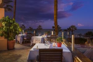a restaurant with tables and a view of the ocean at Elba Estepona Gran Hotel & Thalasso Spa in Estepona