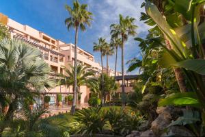 a building with palm trees in front of it at Elba Estepona Gran Hotel & Thalasso Spa in Estepona