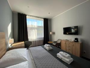a hotel room with a bed with towels on it at Saraya Wellness & Penzion in Teplice