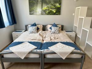a bed with blue and white blankets and pillows on it at Apartments MIYABI in Maribor
