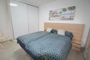 a bedroom with a bed with a blue comforter at Apartamento Avenida Altea 19 in Altea