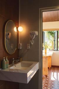 a bathroom with a sink and a mirror at Gỗ Bungalow & Homestay in Hoat
