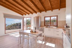 a kitchen with a table and chairs and a large window at Los Barranquillos in Firgas