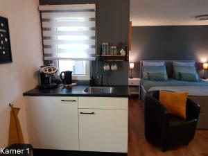 a kitchen with a sink and a bed in a room at Bed & Breakfast de Ruijter in Oud-Gastel