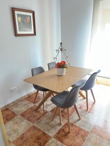 a dining room table with chairs and a vase of flowers at Apartamento 7 adultos in Rueda +16 photos