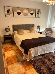a bedroom with a large bed with a brown blanket at Apartamento 7 adultos in Rueda