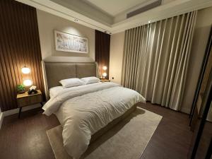 Un dormitorio con una cama grande con sábanas blancas. en Kindah Apartment, en Yeda 19 fotos más