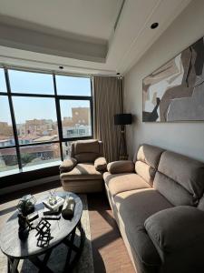 una sala de estar con un sofá y una mesa en Kindah Apartment, en Yeda