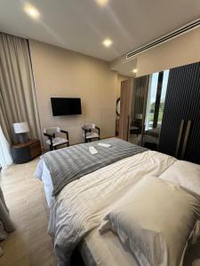 a bedroom with a large bed and a flat screen tv at VILLA Kachreti Ambassadori Golf Resort in Kachretʼi