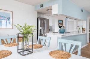 a kitchen with a table with chairs and a refrigerator at Summer Winds 231-B condo in Salter Path