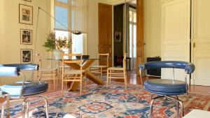 a room with chairs and a table and a dining room at Le Saint Apolline - Sète, Appartement Haussmanien in Sète