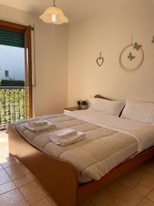 a bedroom with a large bed with towels on it at Mimì apartment - Vicino a Gardaland in Peschiera del Garda