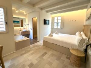 休达德亚SetBlaus Boutique Hotel的一间带床的卧室和一间带浴缸的浴室