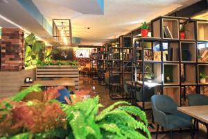 a restaurant with tables and chairs and plants at Scandi Hotel in Oral