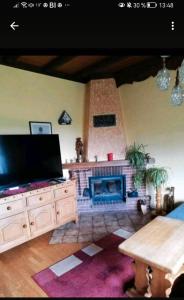 a living room with a fireplace and a flat screen tv at Eselhof Oberlascheid in Oberlascheid