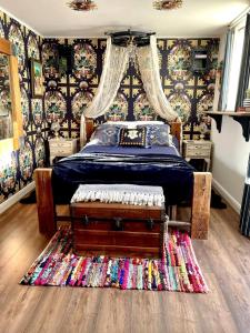a bedroom with a bed with a blue comforter and a rug at Golspie House, Margate in Margate