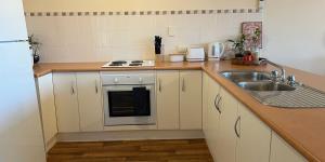 a small kitchen with a sink and a stove at The Palms in Loxton