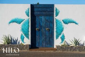 a blue door with dolphins painted on the side of a building at Turtle Beach Villa les 3 Bassins by HILO Collection - 14 people - Pool, gym and Ocean private access in La Saline Les hauts 