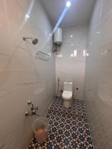 a bathroom with a toilet and a bucket in it at Rio Grande Retreat in Kodaikānāl