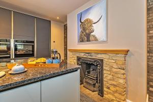 una cocina con chimenea y una foto de un toro en Finest Retreats - Ttich Manor Retreat, en Milton Keynes